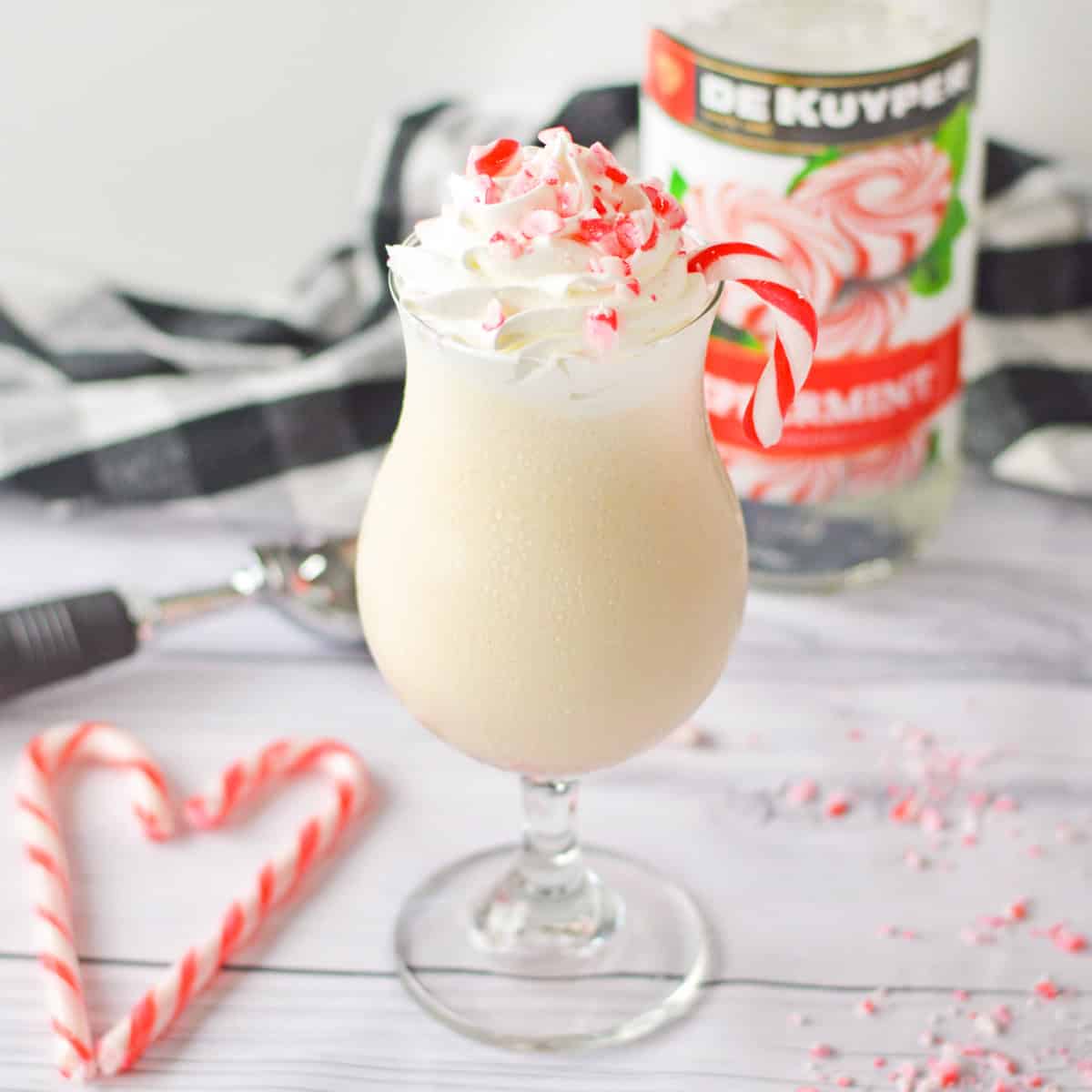 Boozy peppermint milkshake with whipped cream and candy cane topping.