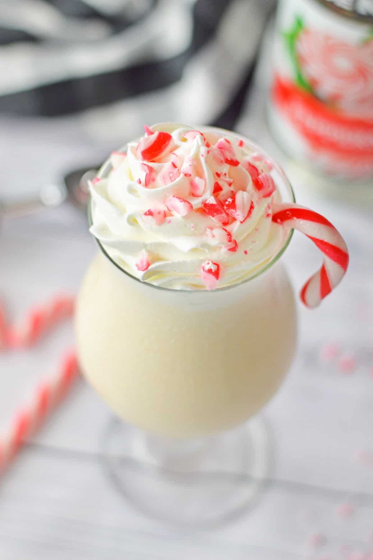 Frozen peppermint cocktail garnished with whipped cream and crushed candy canes.