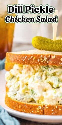A Pinterest image showing a close-up of a thick chicken pickle salad sandwich. A skewer holds a small pickle on top. The text reads, "Dill Pickle Chicken Salad."
