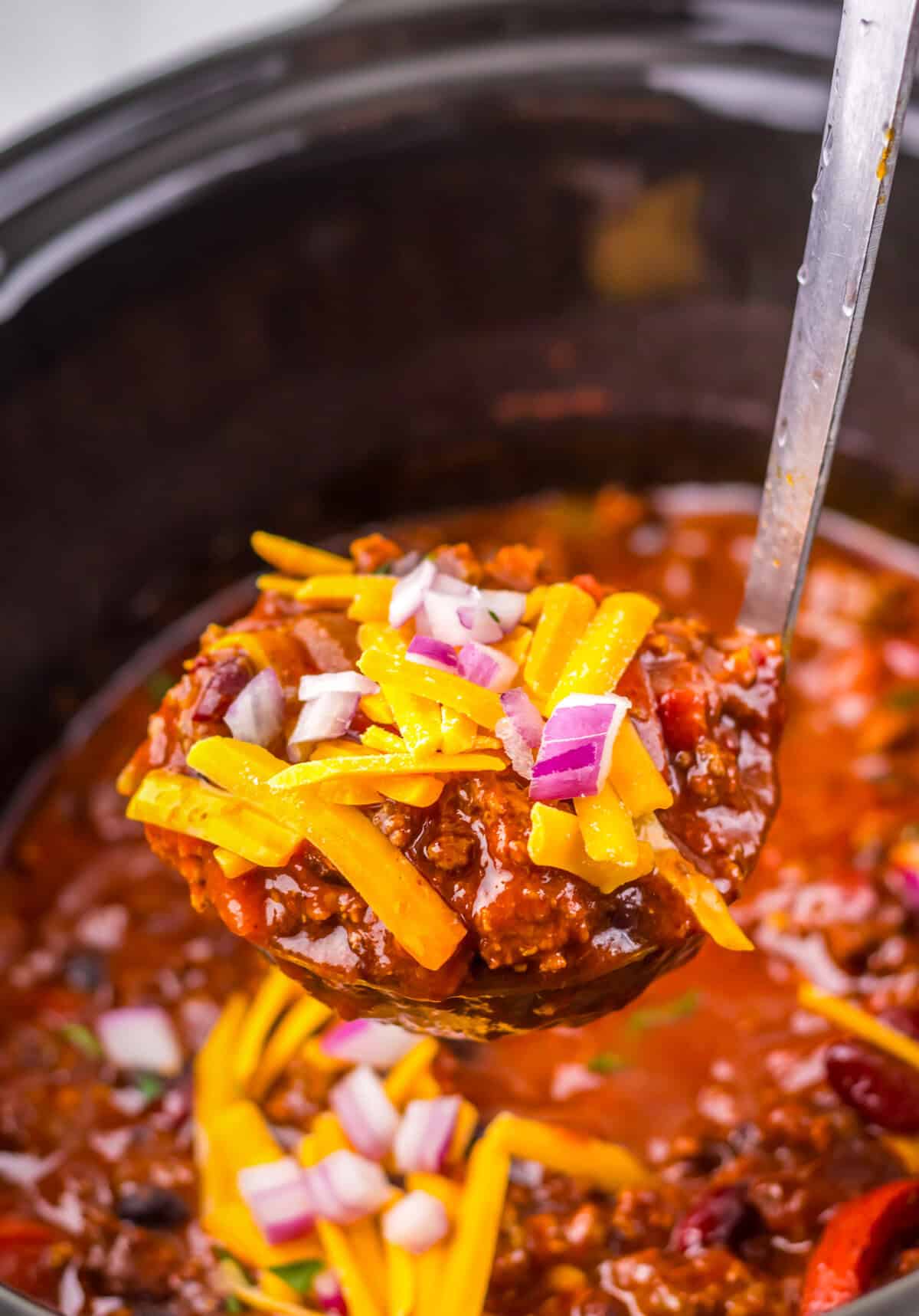 Ladle of dr pepper chili lifted from slow cooker.
