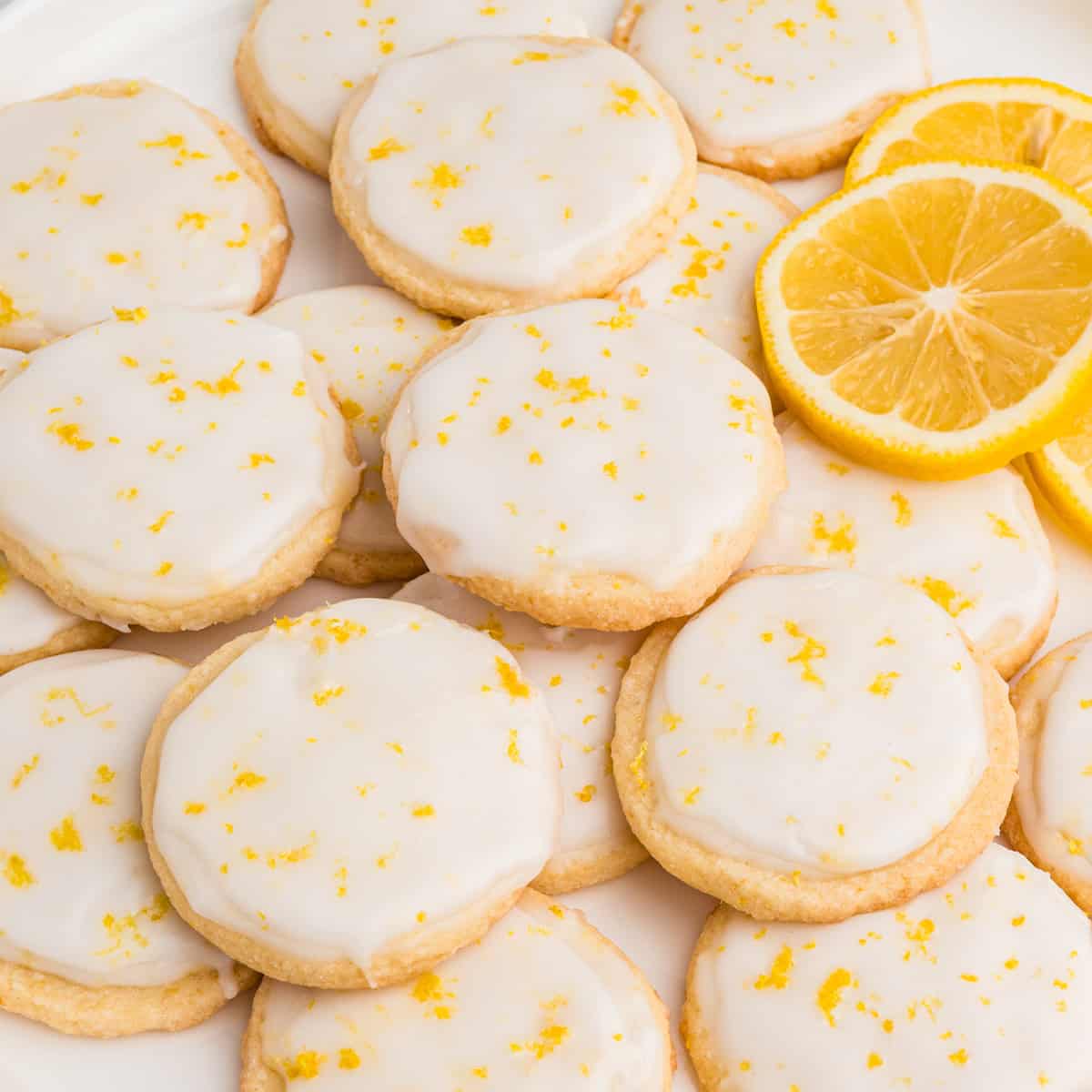 A plate of slice and bake lemon shortbread cookies with lemon glaze.