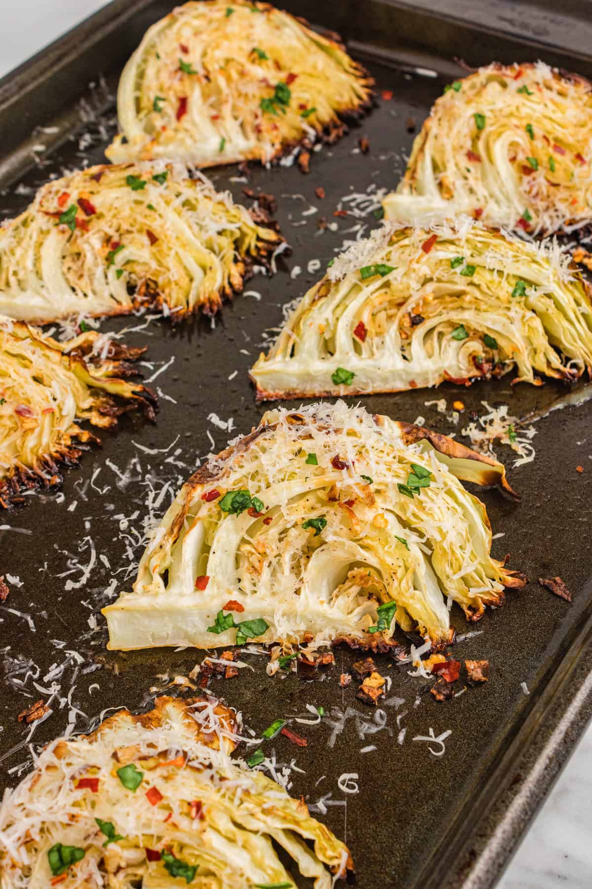 Garlic parmesan roasted cabbage wedges on sheet pan.