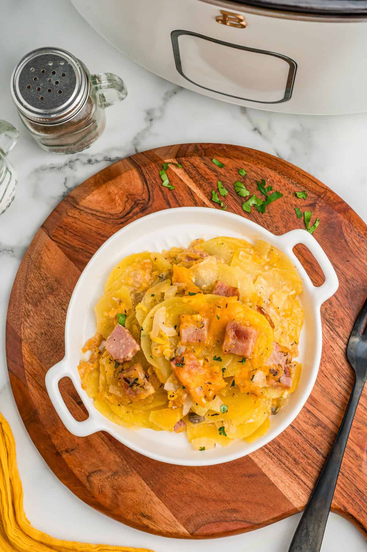 A plated serving of scalloped potatoes with ham.