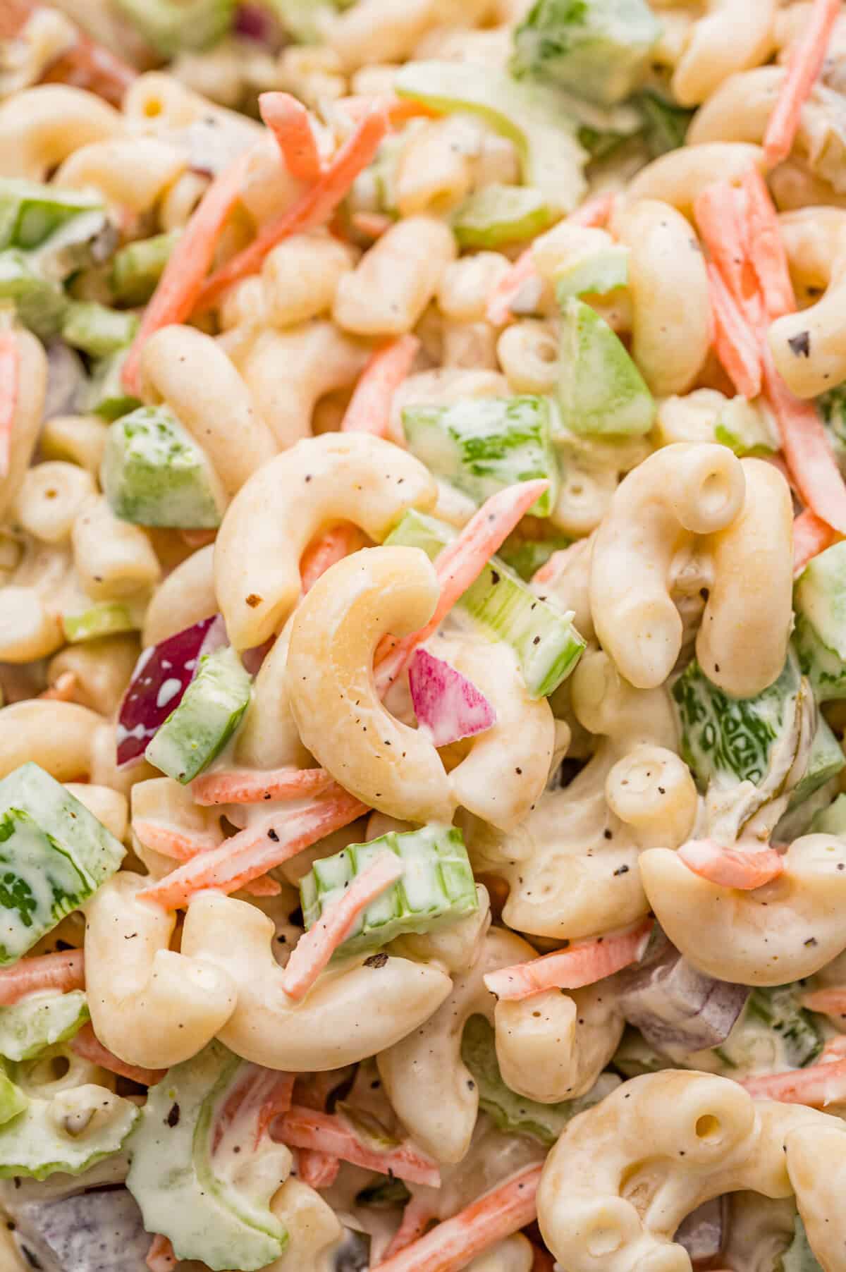 Close-up of creamy classic macaroni salad with vegetables.