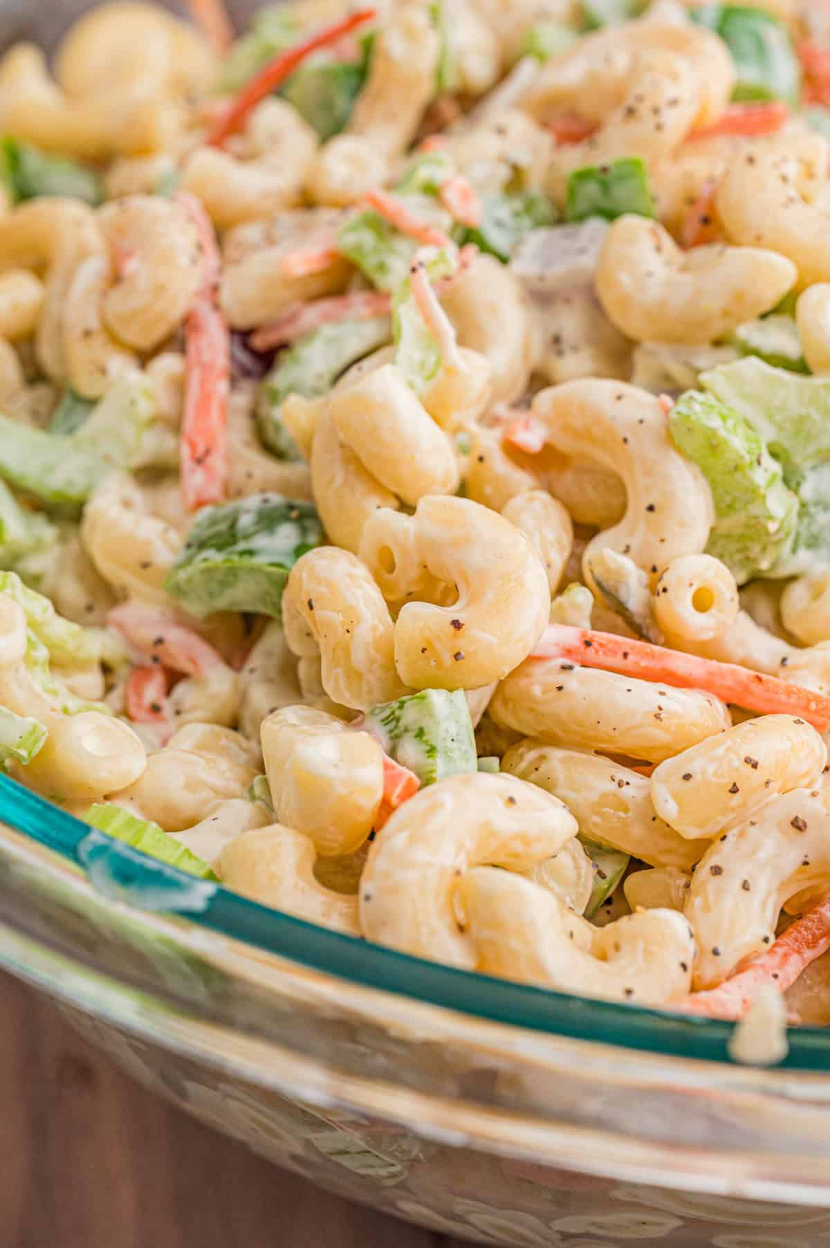 Close-up of cold macaroni salad in a glass bowl.