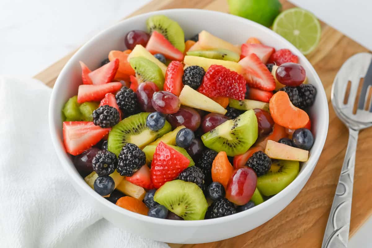 Side view of fruit salad in a white bowl.