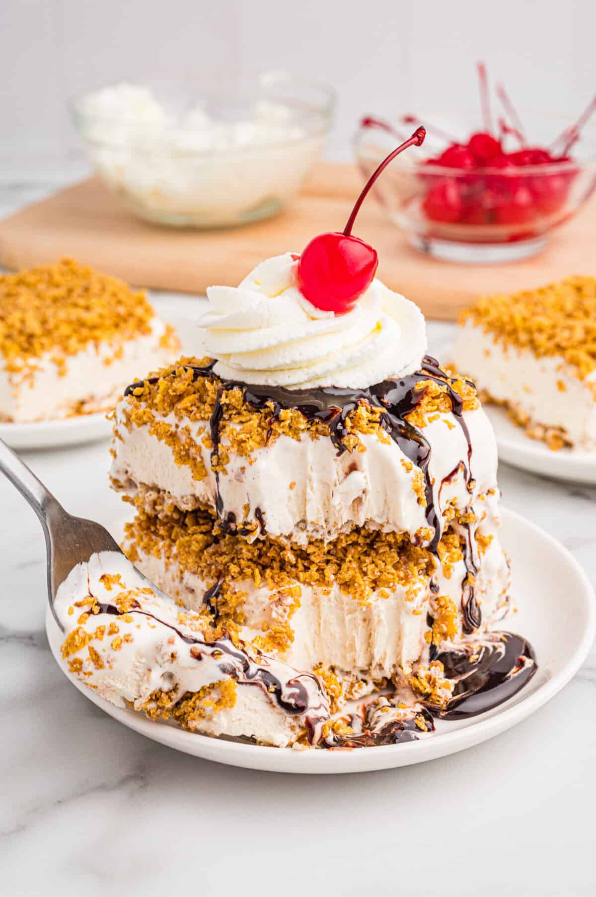 Layered fried ice cream dessert with whipped cream, chocolate syrup, and a cherry.