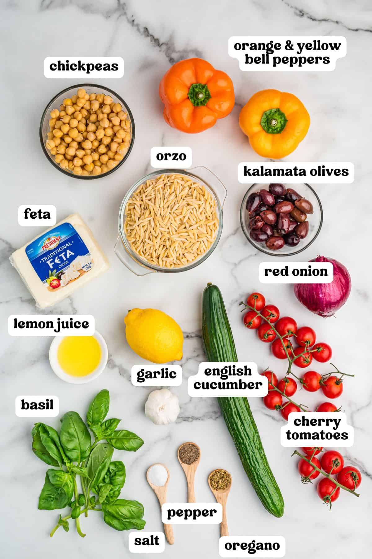 Overhead image showing individual ingredients for orzo salad, each labeled: chickpeas, orange and yellow bell peppers, orzo, kalamata olives, red onion, cherry tomatoes, English cucumber, garlic, lemon juice, feta cheese, basil, salt, pepper, and oregano, all laid out neatly on a marble background.