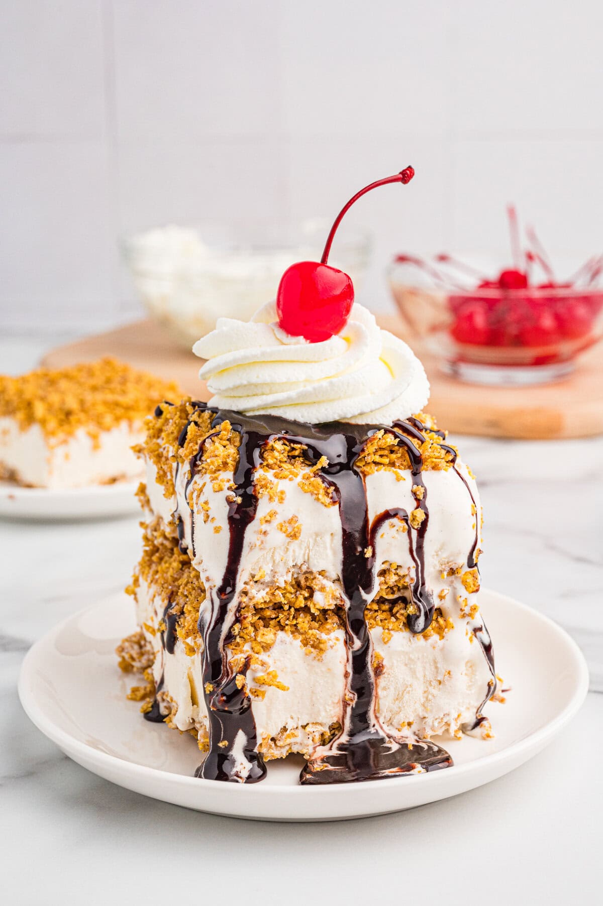 Fried ice cream dessert topped with chocolate syrup, whipped cream, and a cherry.