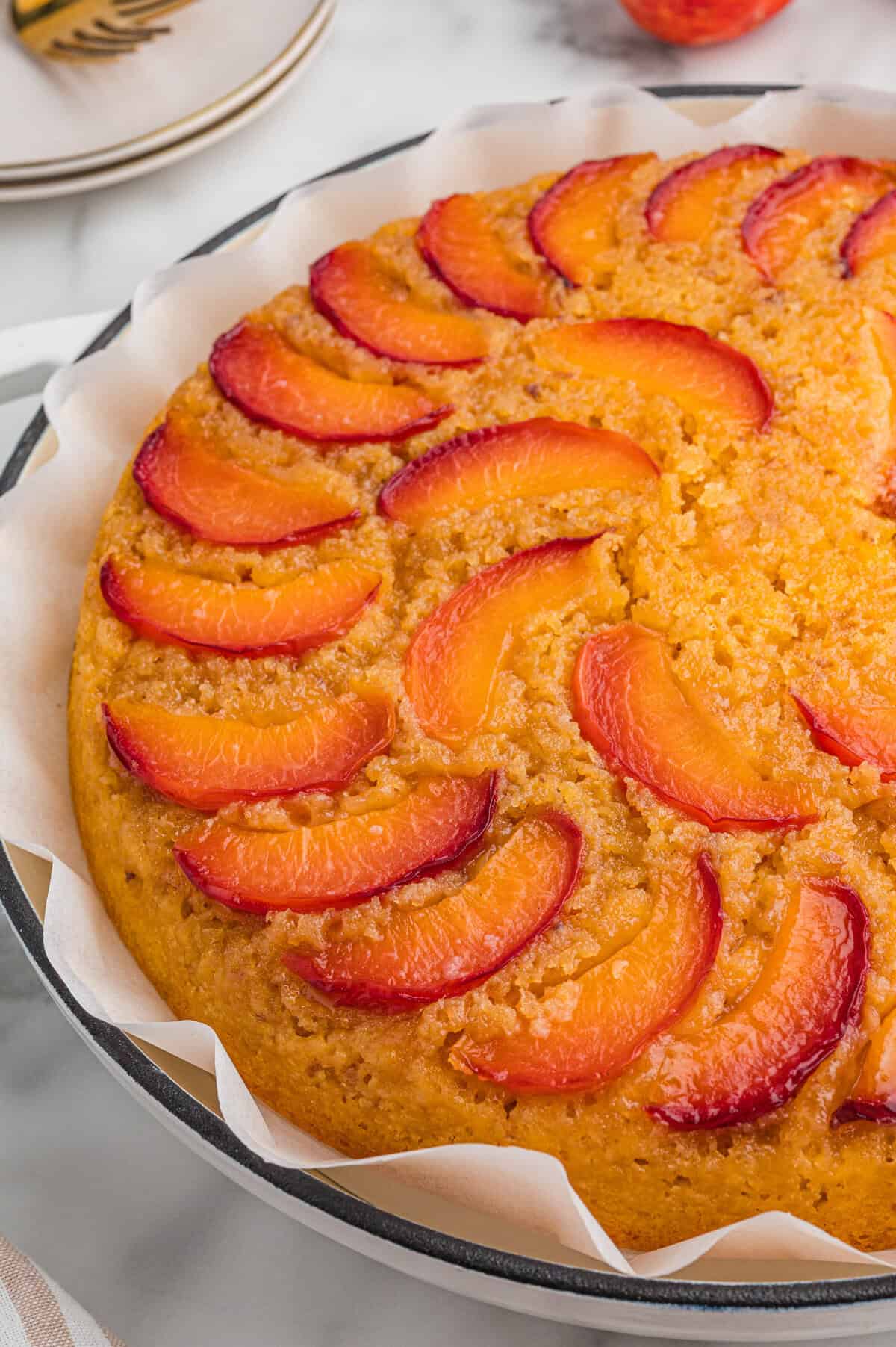 An upside down peach cake made with cake mix, showing the detailed placement of peach slices on top and the golden, fluffy texture of the baked cake.