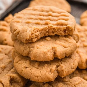 Stack of 3 ingredient peanut butter cookies with a bite taken from the top one.