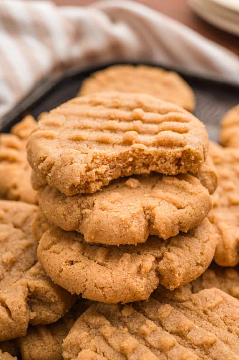Stack of 3 ingredient peanut butter cookies with a bite taken from the top one.