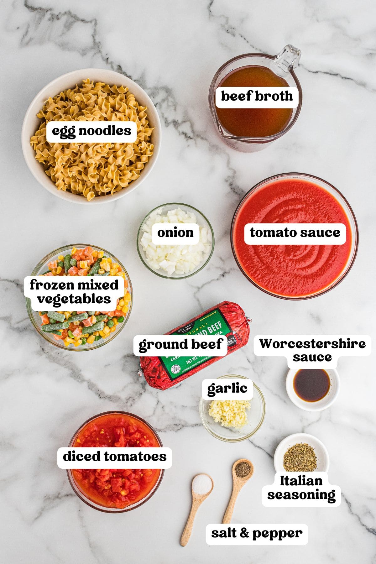 Ingredients for hamburger noodle soup, including egg noodles, ground beef, diced tomatoes, tomato sauce, beef broth, frozen mixed vegetables, onion, garlic, Worcestershire sauce, Italian seasoning, and salt and pepper.