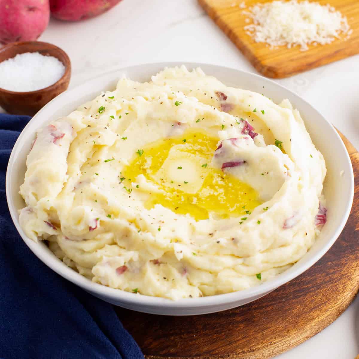 Bowl of red skin mashed potatoes with butter and herbs.