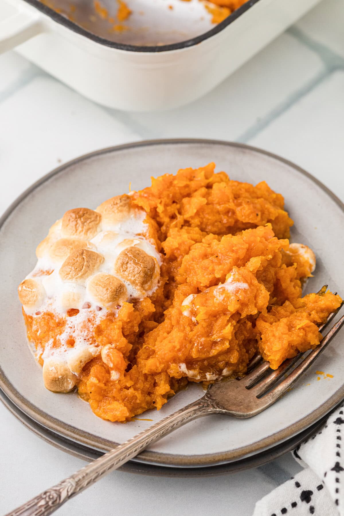 Plated serving of sweet potato casserole with marshmallows.