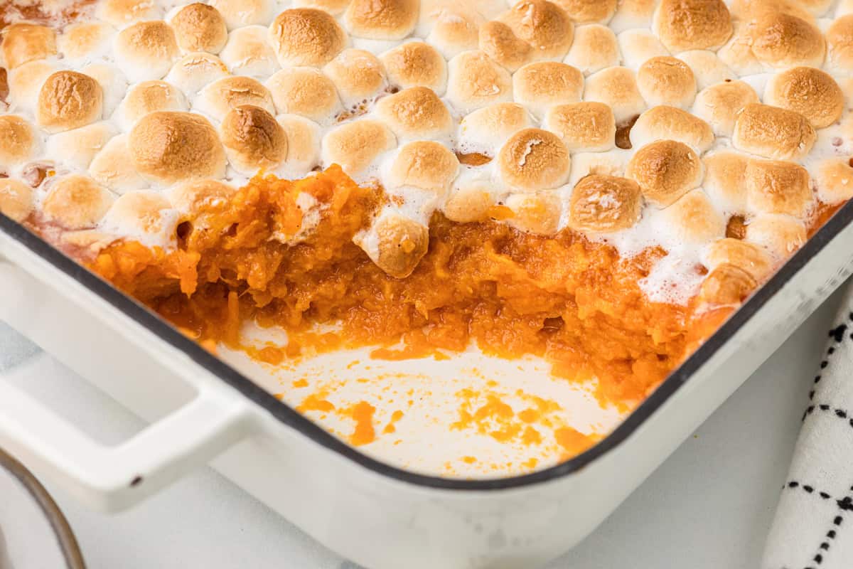 Sweet potato marshmallow casserole in a dish with a portion removed.