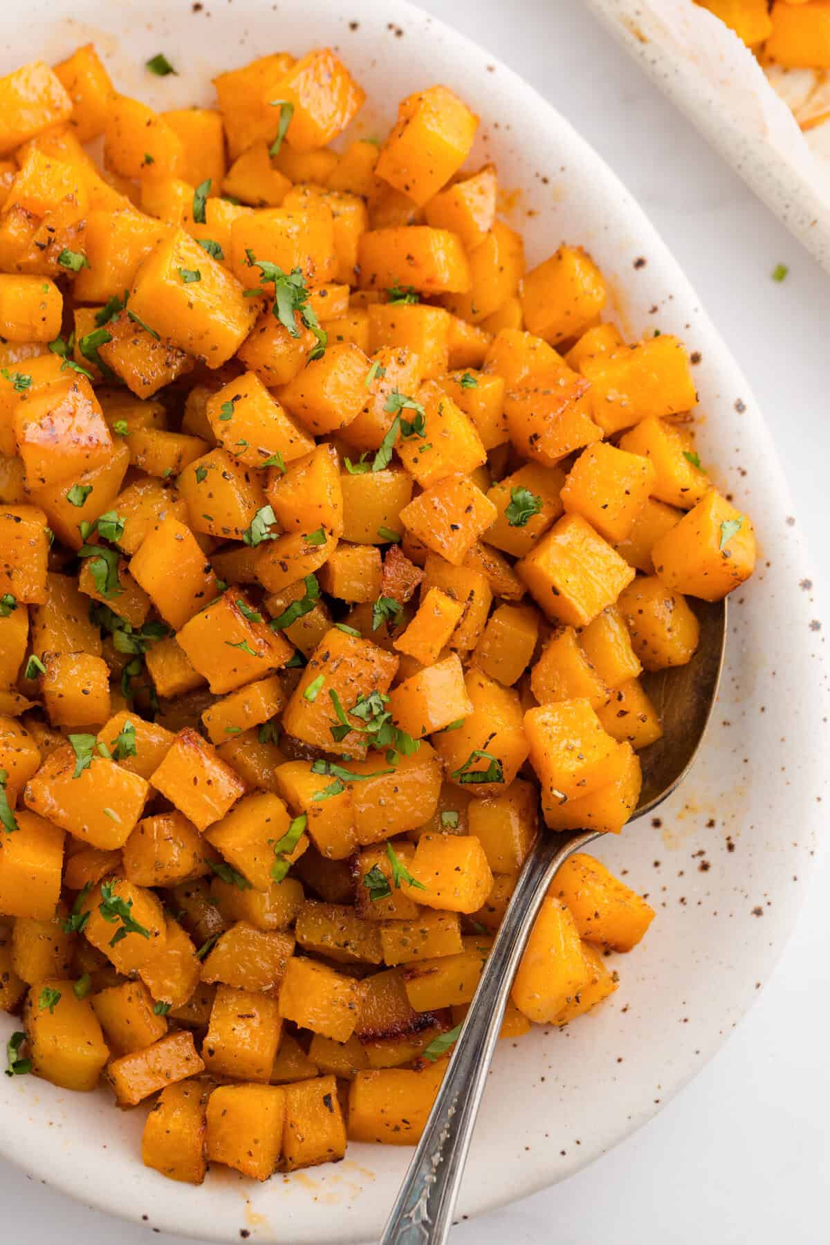Close-up of roasted butternut squash cubes in a serving dish.