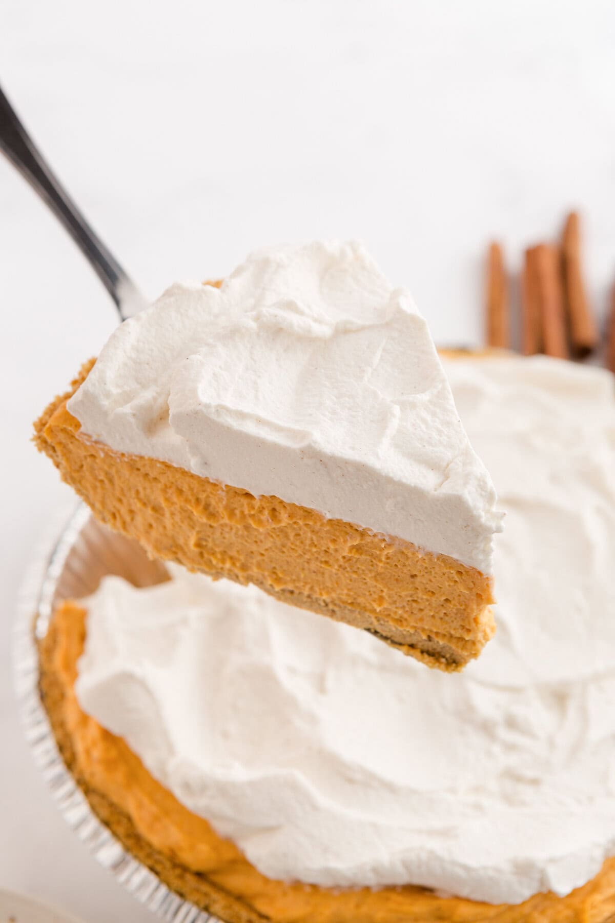 Slice of no-bake pumpkin pie being lifted from the pan.