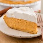 Slice of no-bake pumpkin pie on a plate with a fork.