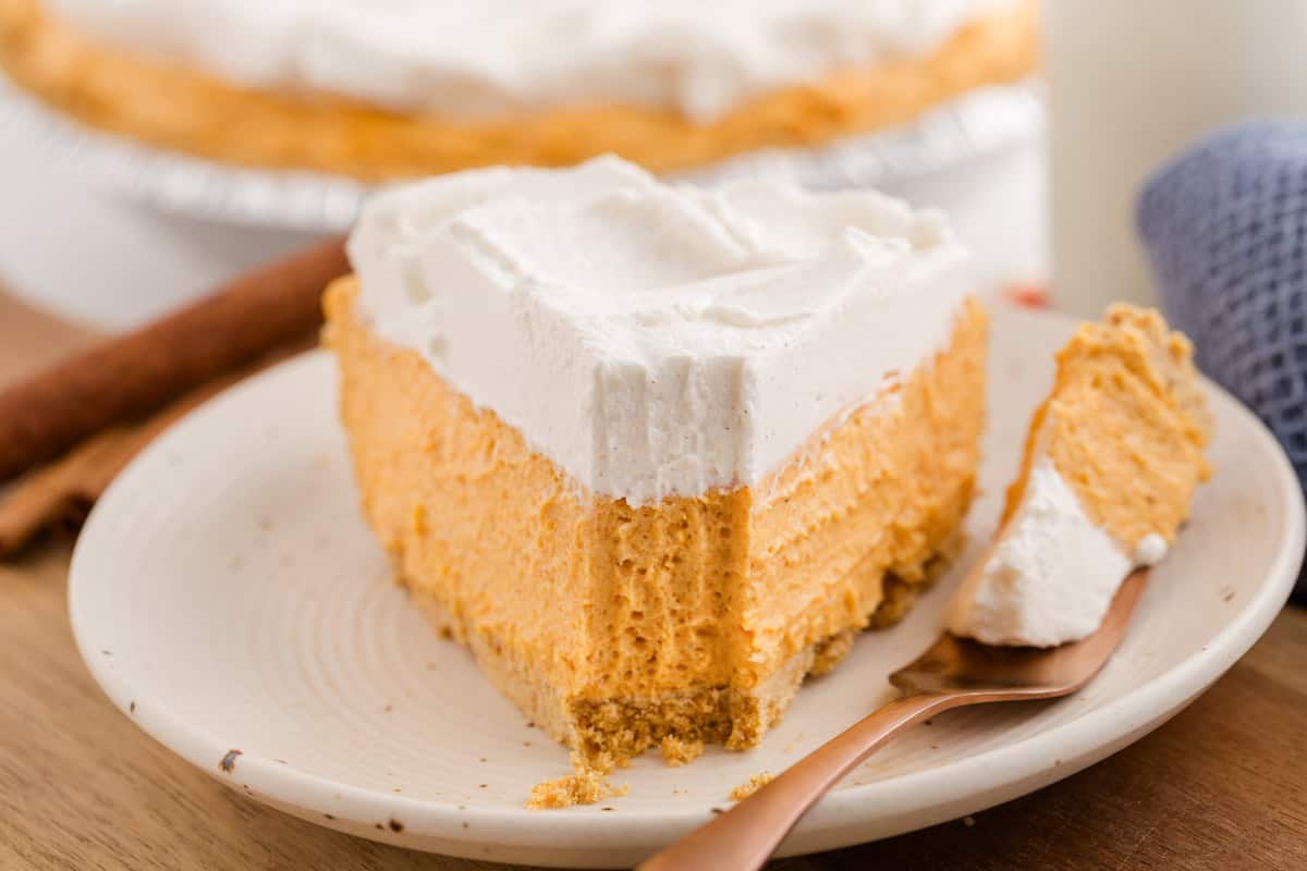 Slice of no-bake pumpkin pie with a bite on a fork.