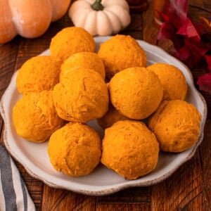 Place of 2 ingredient pumpkin bread rolls with fall decorate in background.