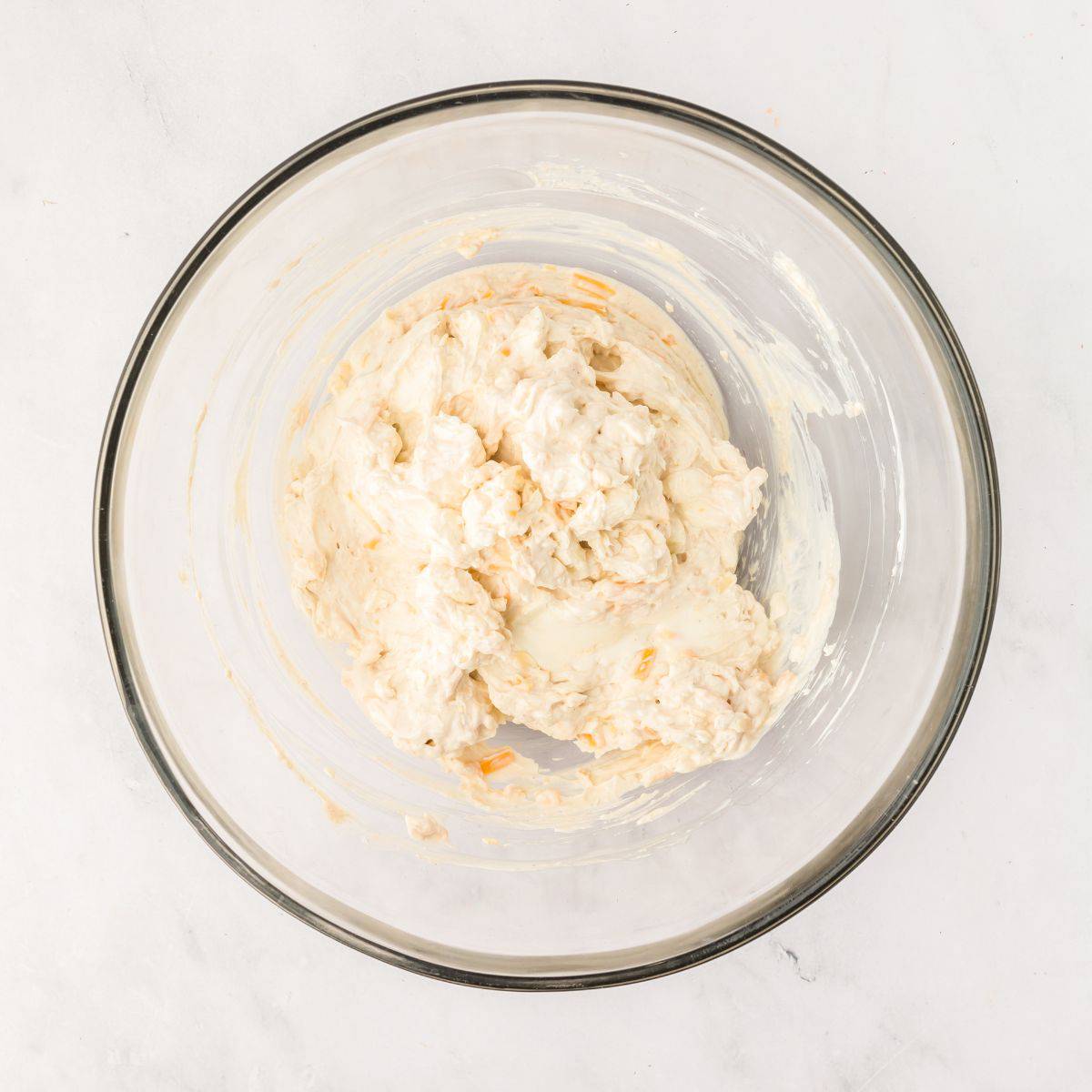 Cheese ball mixture in a glass bowl.