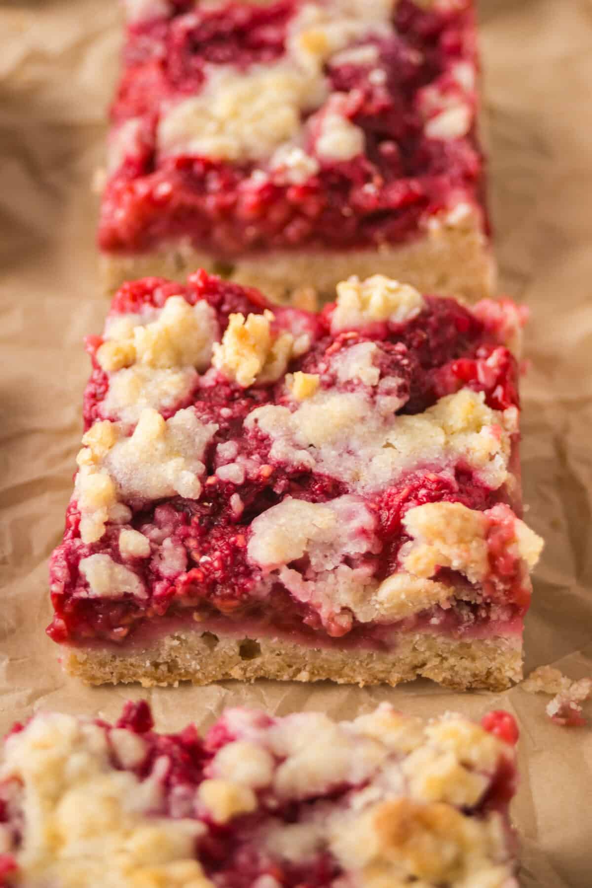 Close-up of a raspberry bar with a golden crust and crumbly topping.