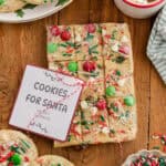 Wrapped break and bake Christmas cookie dough with festive toppings and a “Cookies for Santa” label.