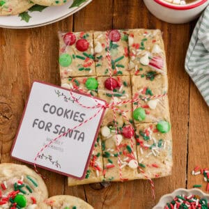 Wrapped break and bake Christmas cookie dough with festive toppings and a “Cookies for Santa” label.
