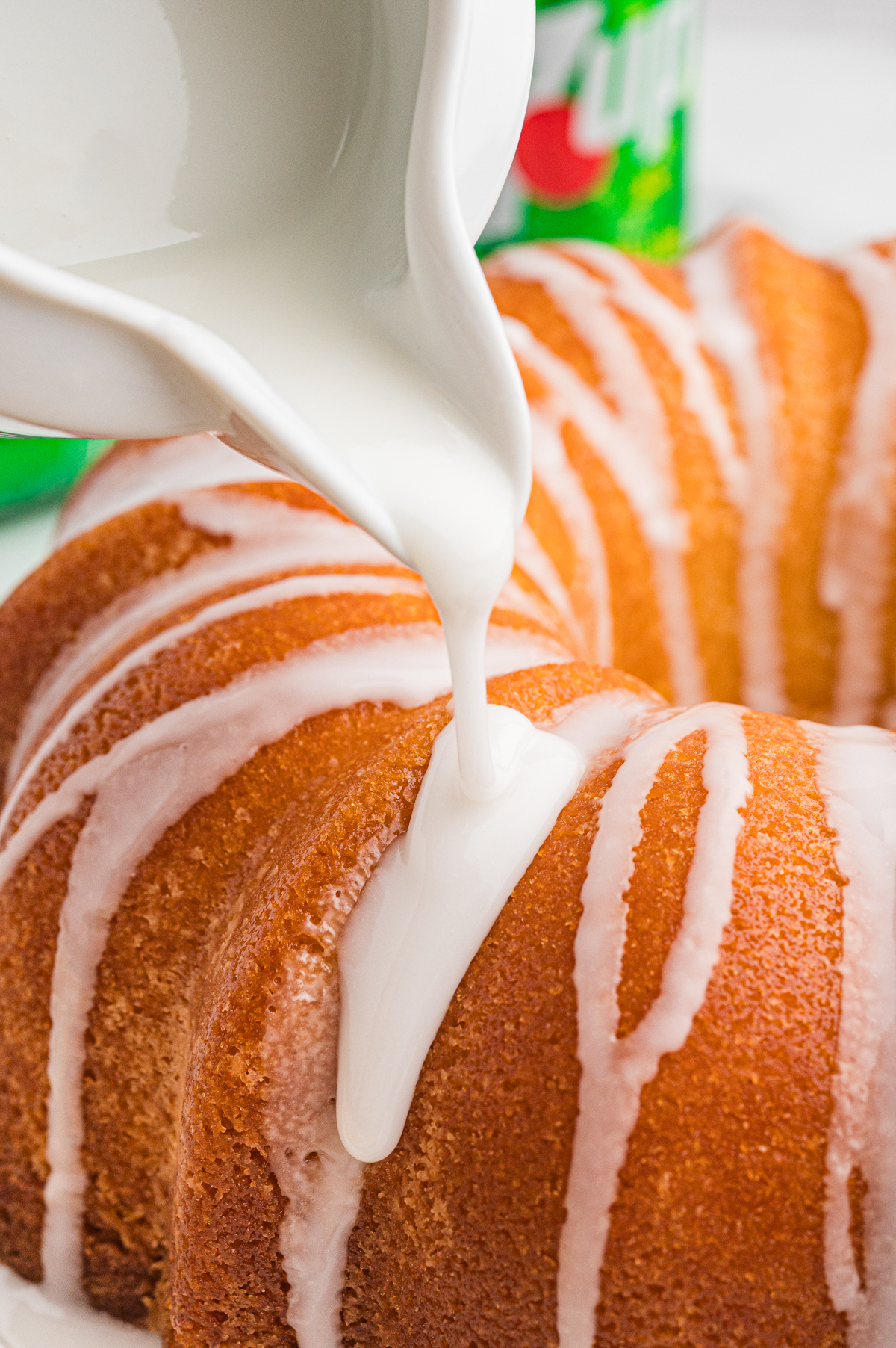 Glaze being drizzled over 7 up cake.