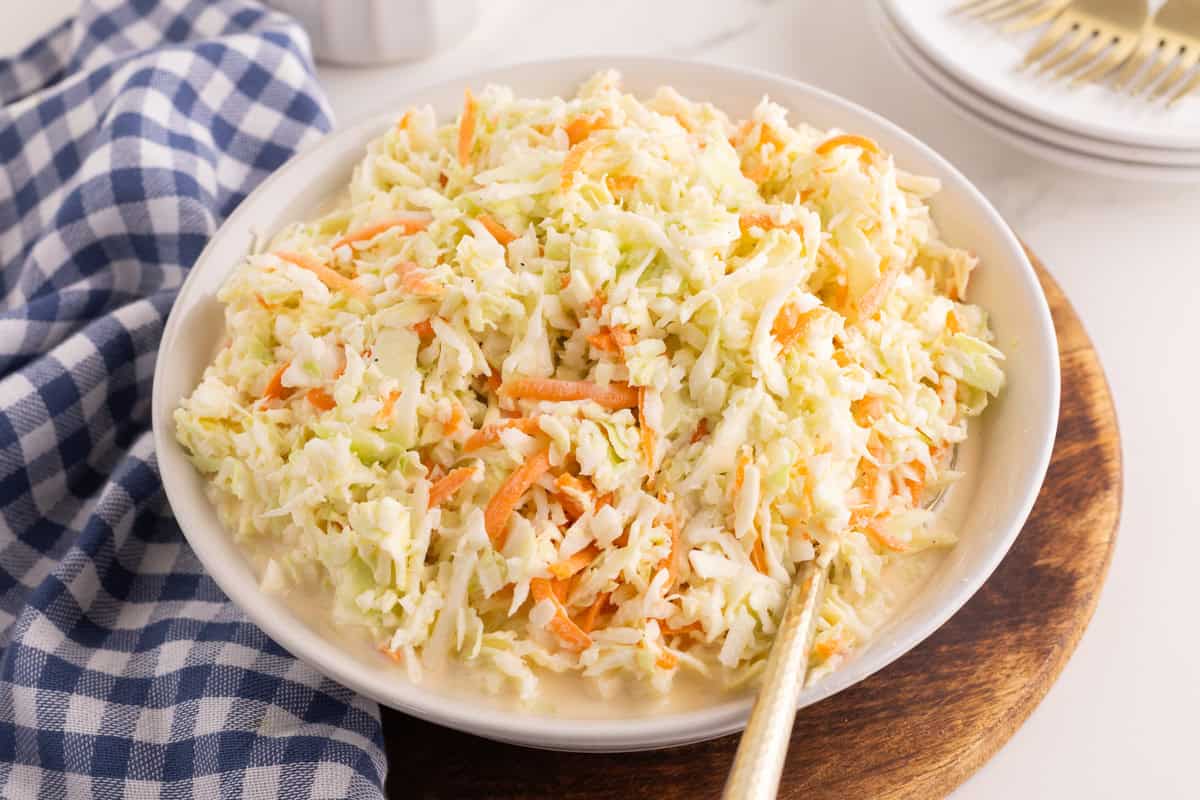Bowl of homemade coleslaw with a spoon resting in it.