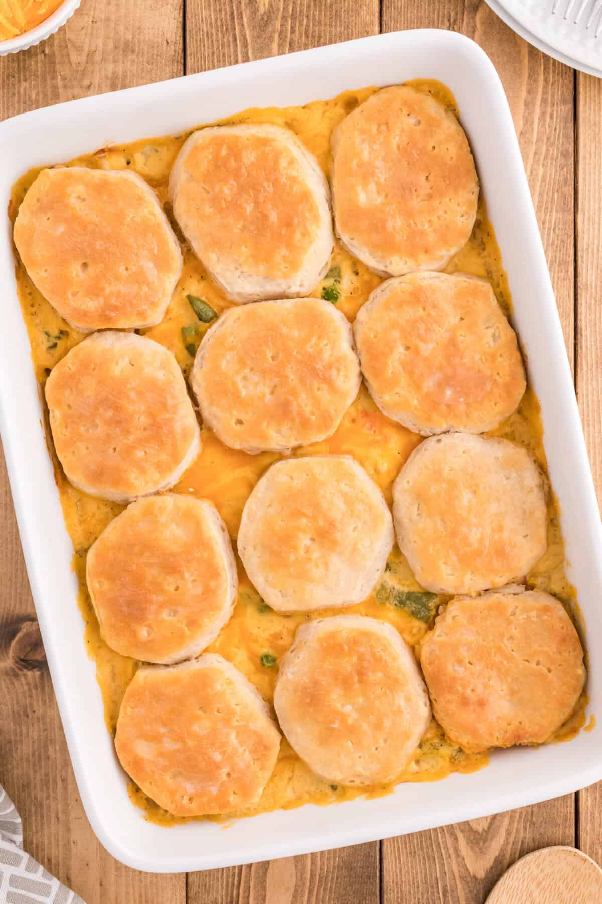 Chicken pot pie casserole with biscuits baked in a white rectangular dish.