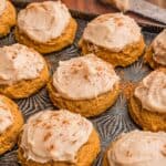 Frosted pumpkin cookies dusted with cinnamon.