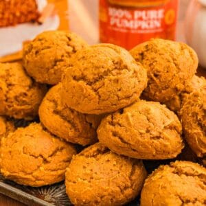 Stacked pumpkin cookies on a dark tray with a 100% pure pumpkin can behind.